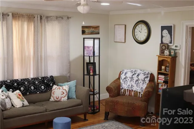 a living room with furniture a clock and a window