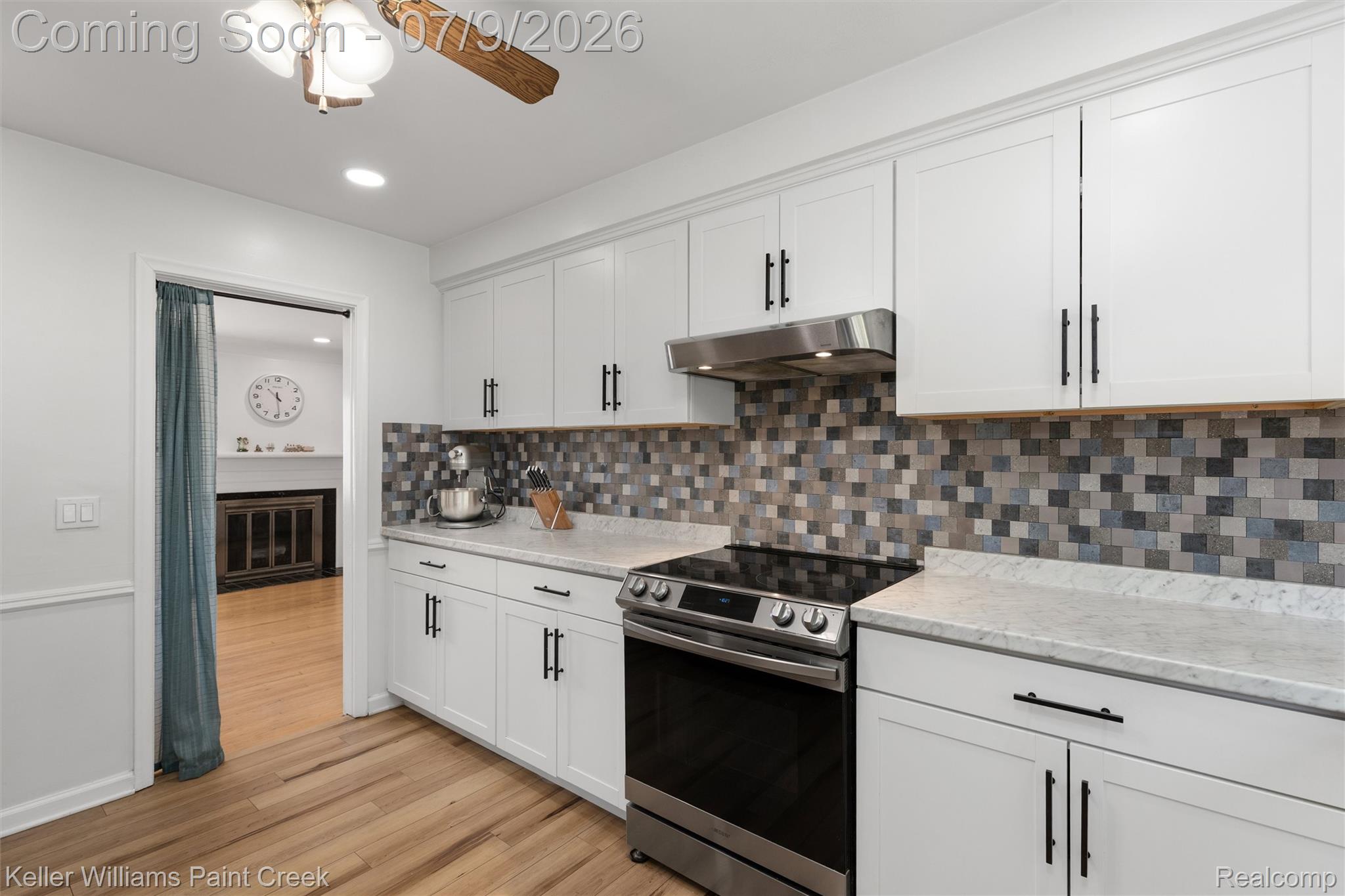 2731 Crooks Road Royal Oak, MI 48073 - Photo 15 of 34 Kitchen with white shaker cabinetry, stainless steel range and hood, mosaic tile backsplash, and light-toned countertops
