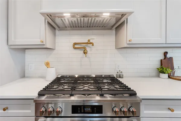 a stove top oven sitting inside of a kitchen