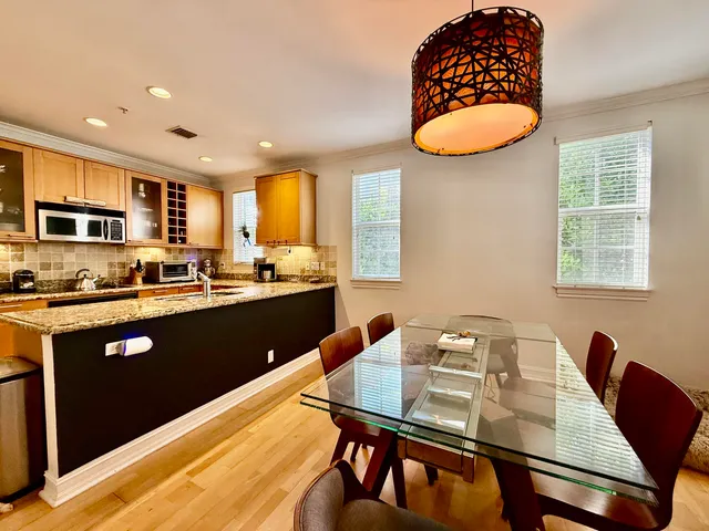 a kitchen with stainless steel appliances granite countertop a stove a sink a dining table and chairs