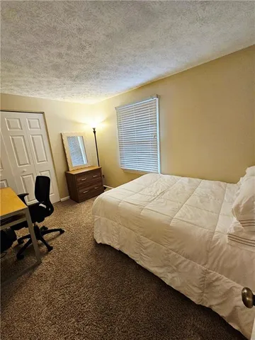 a bedroom with a bed a desk and chair