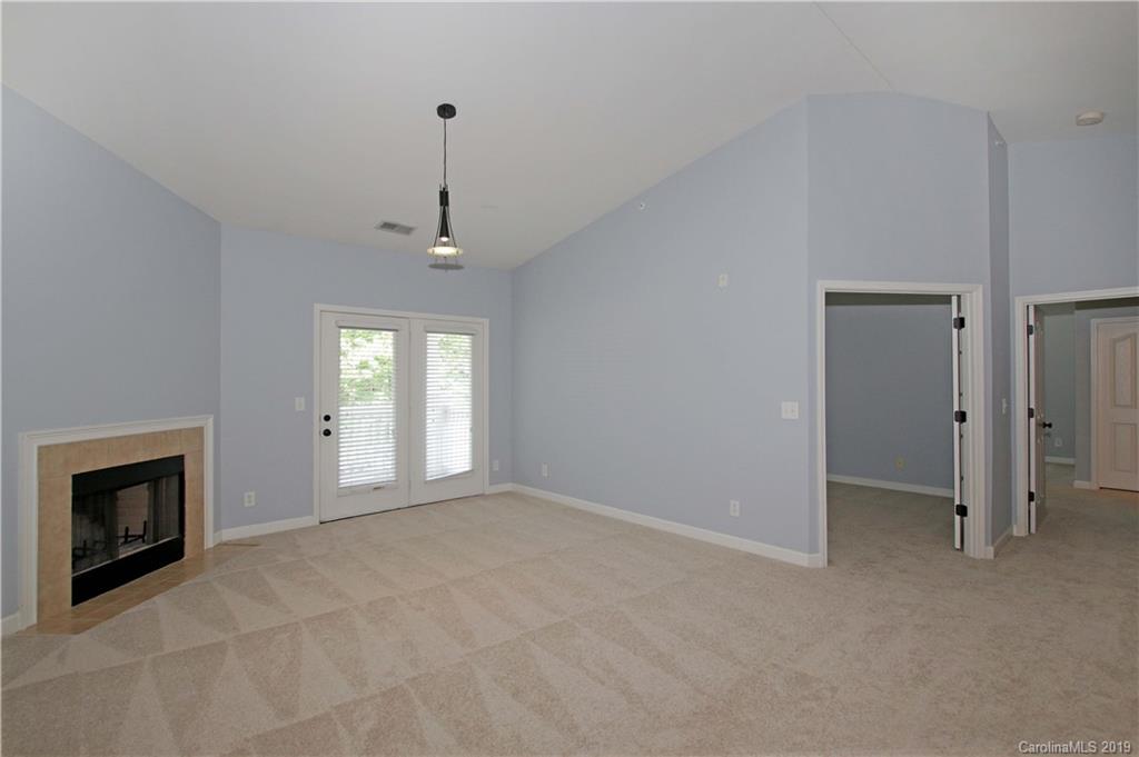 16646 Amberside Road East Cornelius, NC 28031 - Photo 2 of 29 a view of an empty room with a fireplace and a window