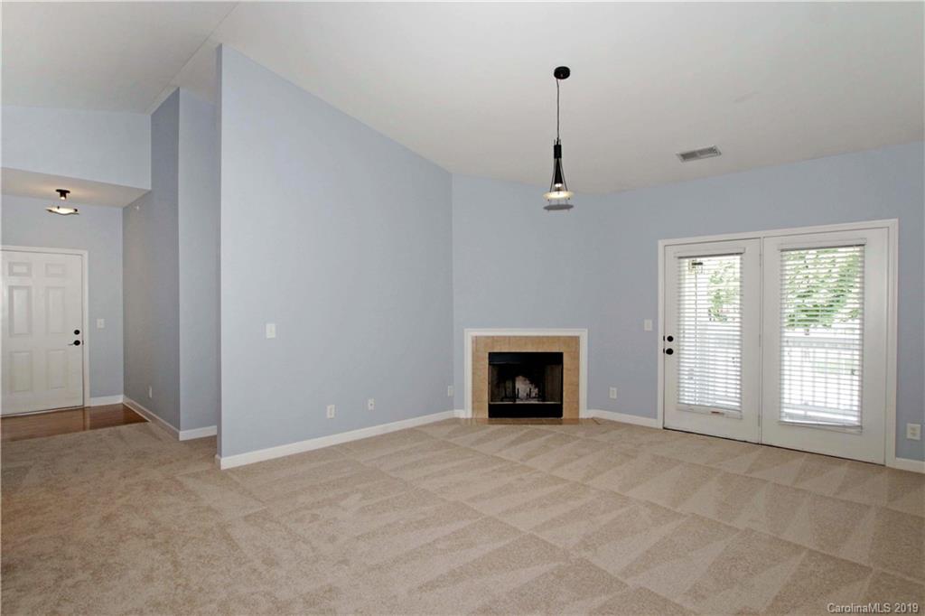 16646 Amberside Road East Cornelius, NC 28031 - Photo 3 of 29 a view of an empty room with a fireplace and a window