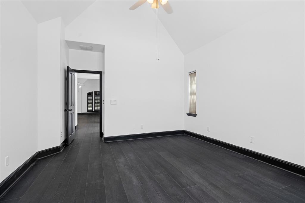 4160 Towne Green Circle Addison, TX 75001 - Photo 11 of 24 Empty room featuring ceiling fan, dark wood finished floors, high vaulted ceiling, and baseboards