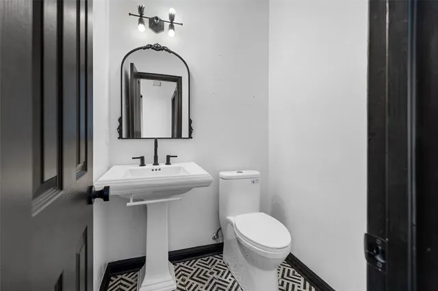 a bathroom with a sink toilet and mirror