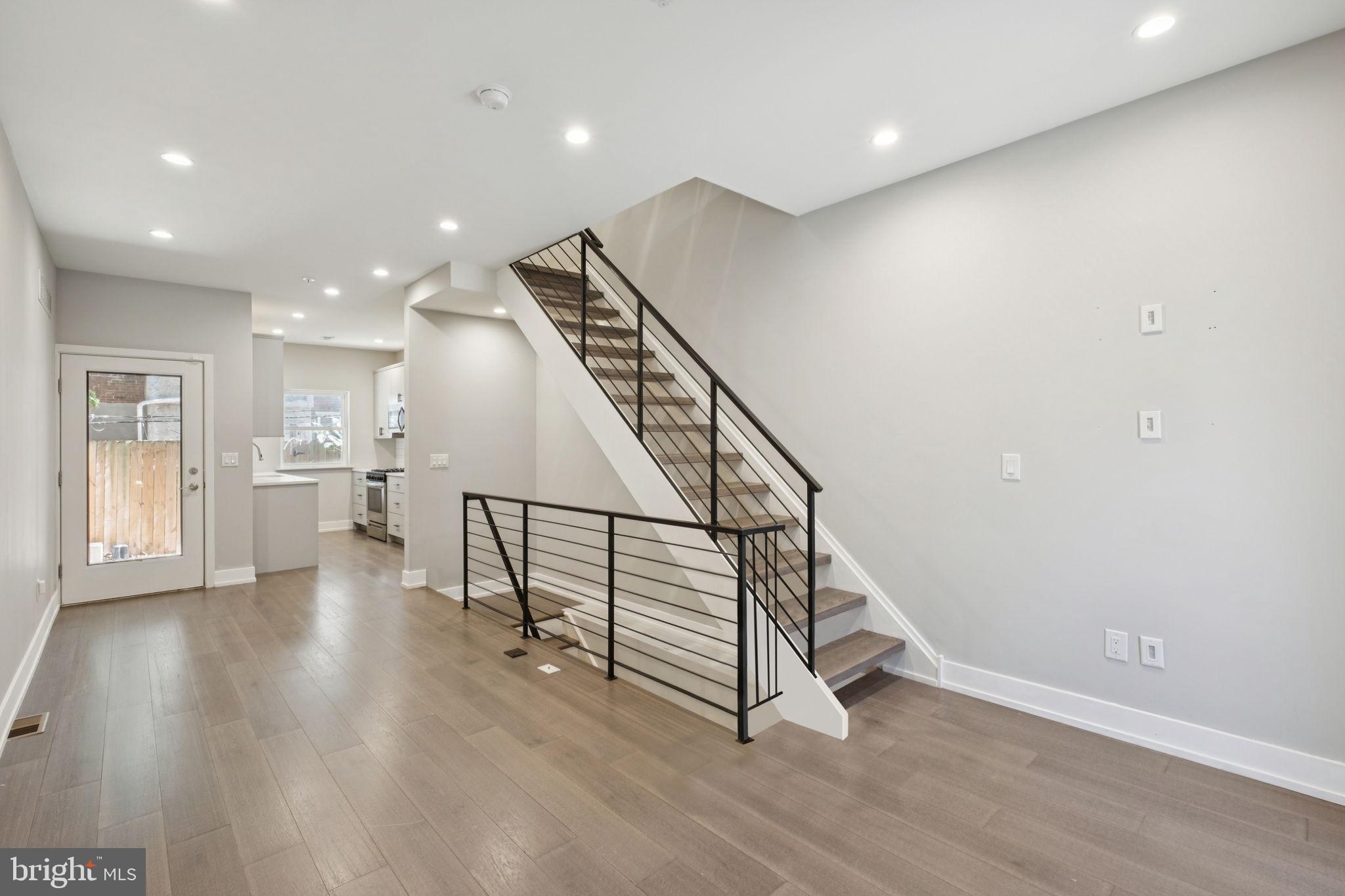 1533 South Lambert Street Philadelphia, PA 19146 - Photo 11 of 29 a view of an empty room with wooden floor stairs and a way to kitchen