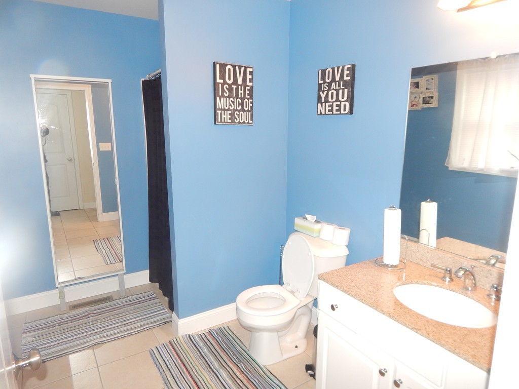 530 Stevens Street Fall River, MA 02721 - Photo 11 of 22 a bathroom with a toilet a sink and mirror