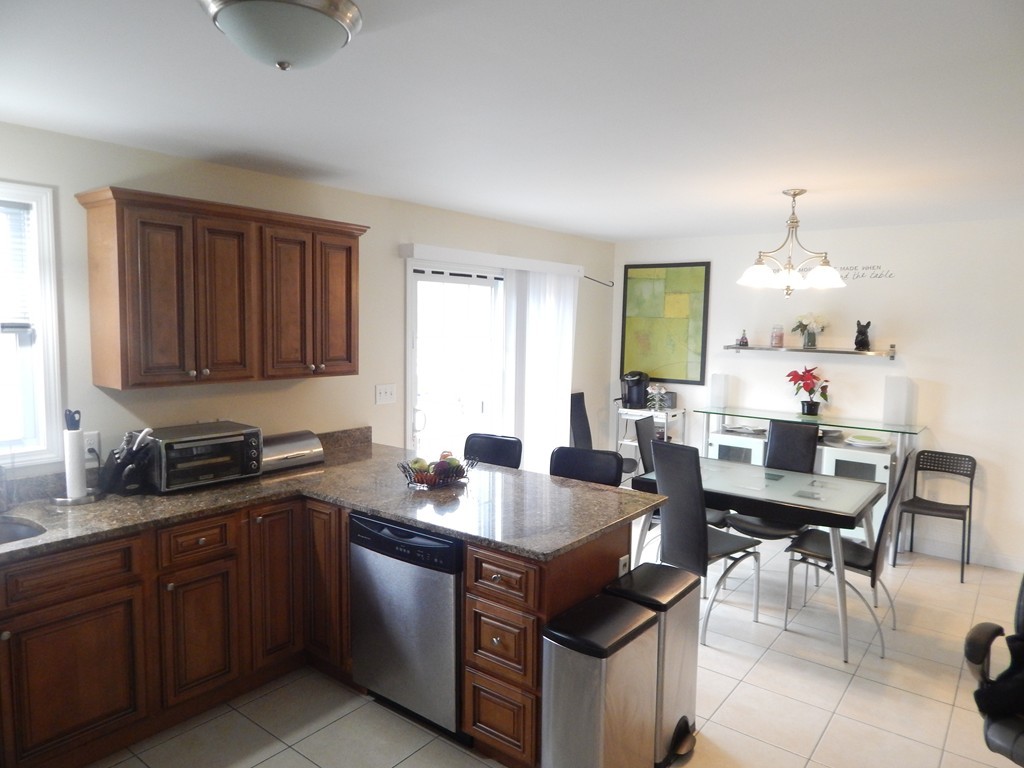 530 Stevens Street Fall River, MA 02721 - Photo 4 of 22 a kitchen with a stove a sink a dining table and chairs
