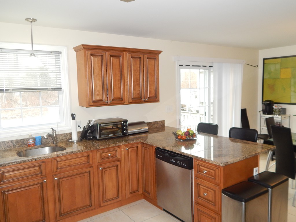 530 Stevens Street Fall River, MA 02721 - Photo 5 of 22 a kitchen with granite countertop a sink stove and cabinets