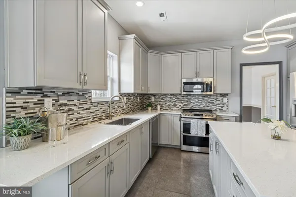 a kitchen with a sink refrigerator and cabinets