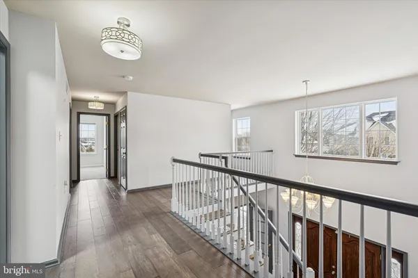 an empty room with wooden floor and a ceiling fan
