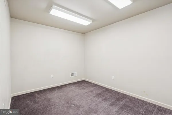 a view of a dry yard with wooden fence