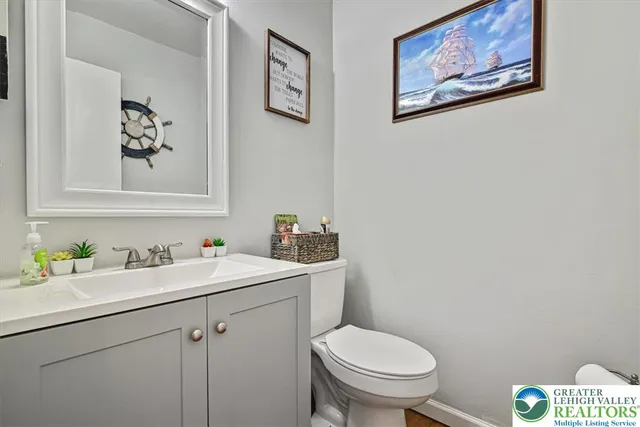 a bathroom with a toilet a sink and mirror