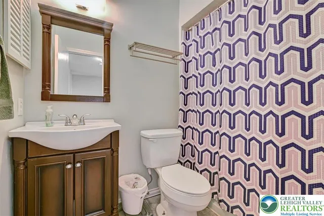 a bathroom with a toilet a sink and a mirror