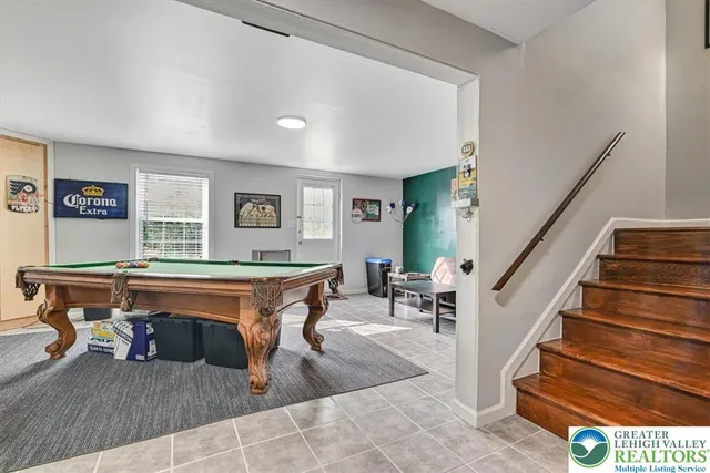 a living room with a table tennis and stairs