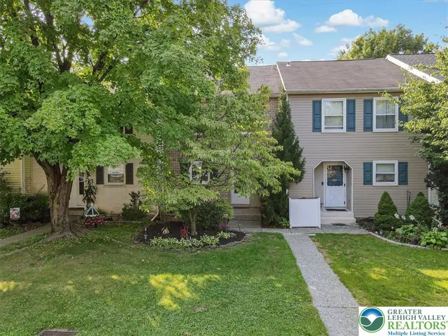 a front view of a house with a garden and yard