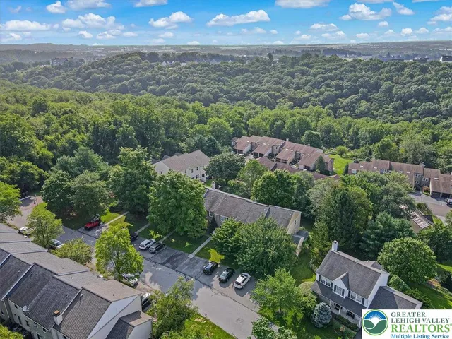 an aerial view of residential houses with outdoor space and trees