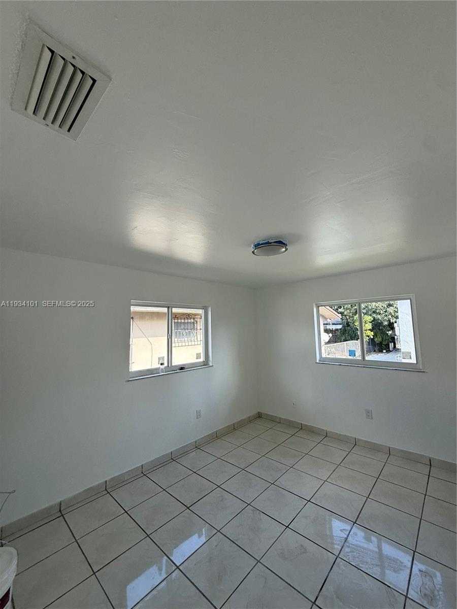 1055 Northwest 34th Avenue, Unit 1055 Miami, FL 33125 - Photo 17 of 19 an empty room with windows