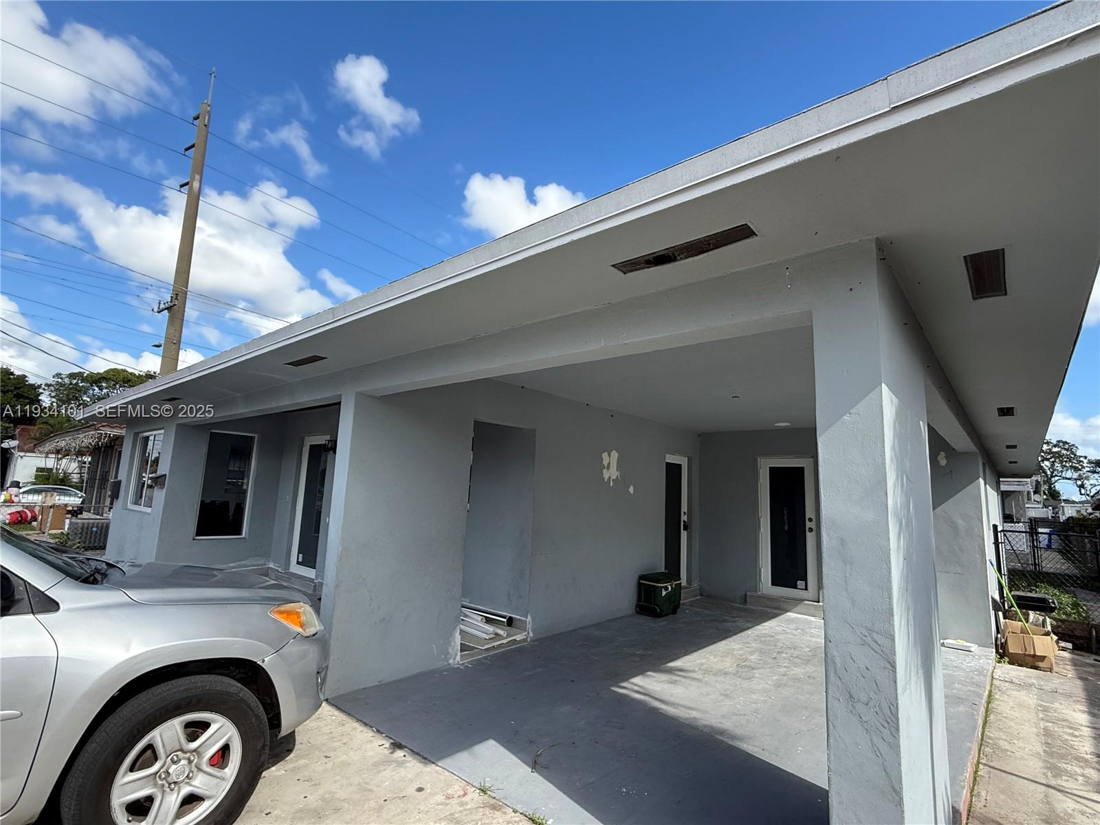 1055 Northwest 34th Avenue, Unit 1055 Miami, FL 33125 - Photo 3 of 19 a front view of a house with parking area