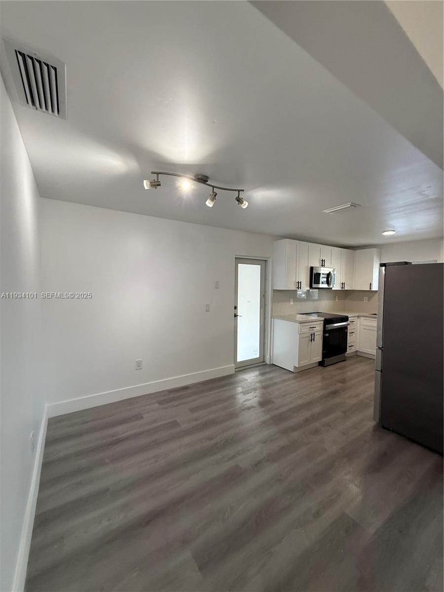 1055 Northwest 34th Avenue, Unit 1055 Miami, FL 33125 - Photo 6 of 19 an empty room with wooden floor