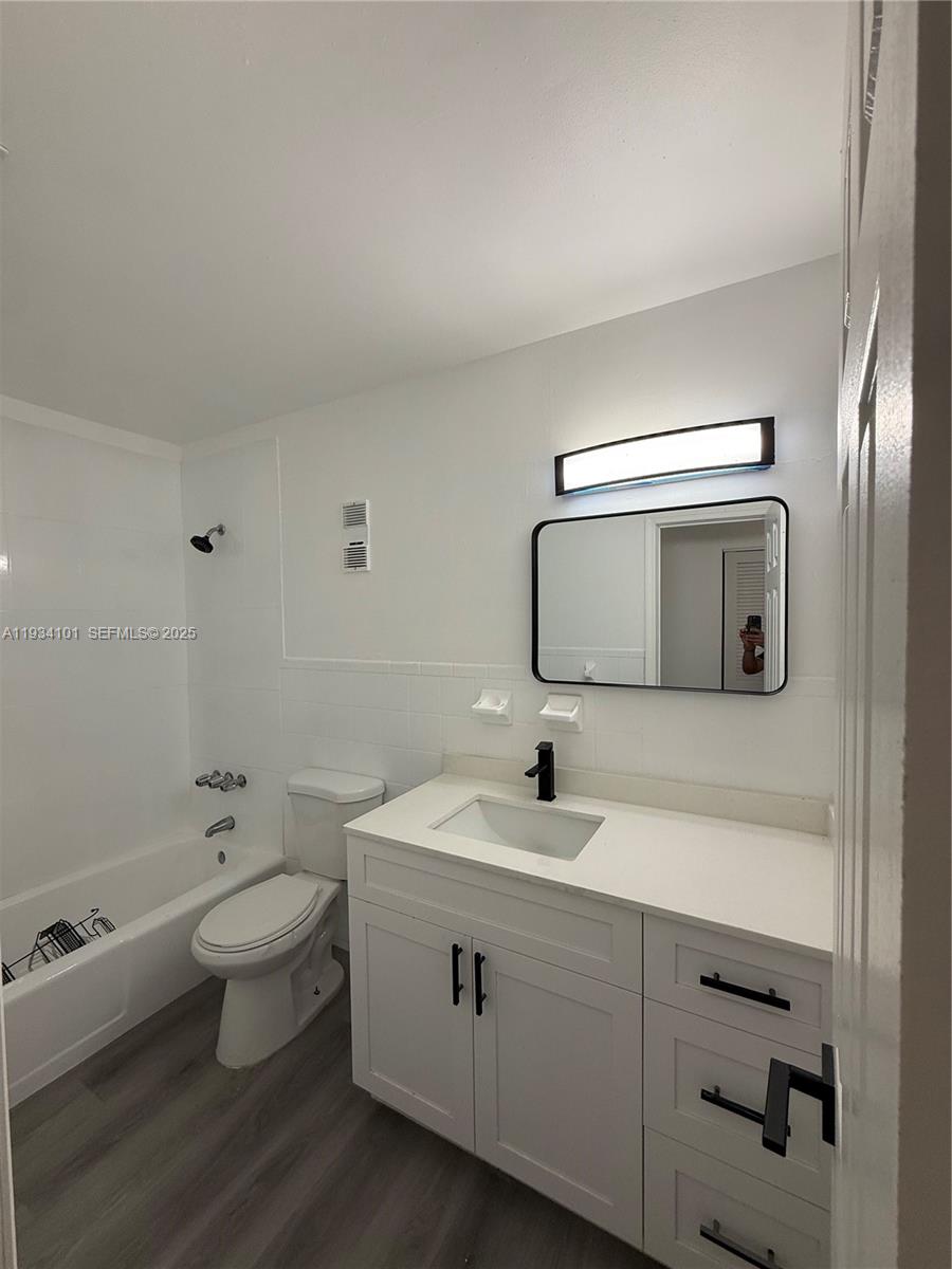 1055 Northwest 34th Avenue, Unit 1055 Miami, FL 33125 - Photo 10 of 19 a bathroom with a toilet sink and mirror