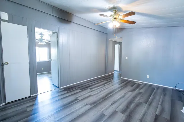 a view of an empty room with window and wooden floor