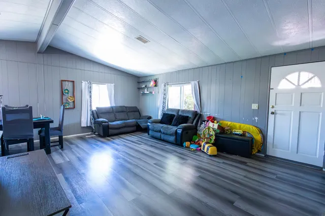 a living room with furniture hard wood floor and a table
