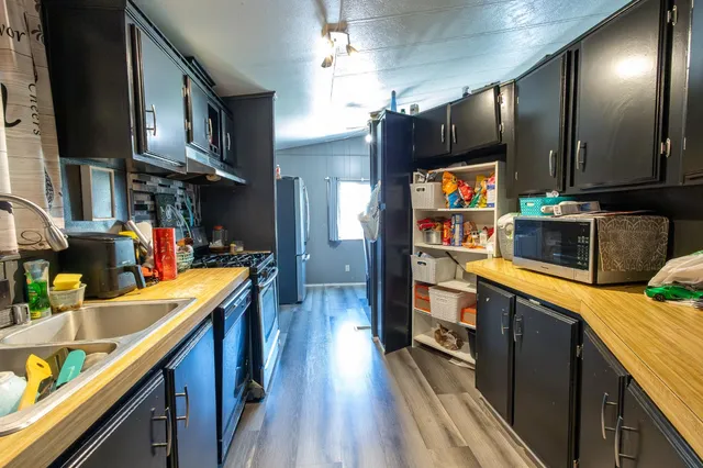 a kitchen view of a kitchen island wooden floor and stainless steel appliances