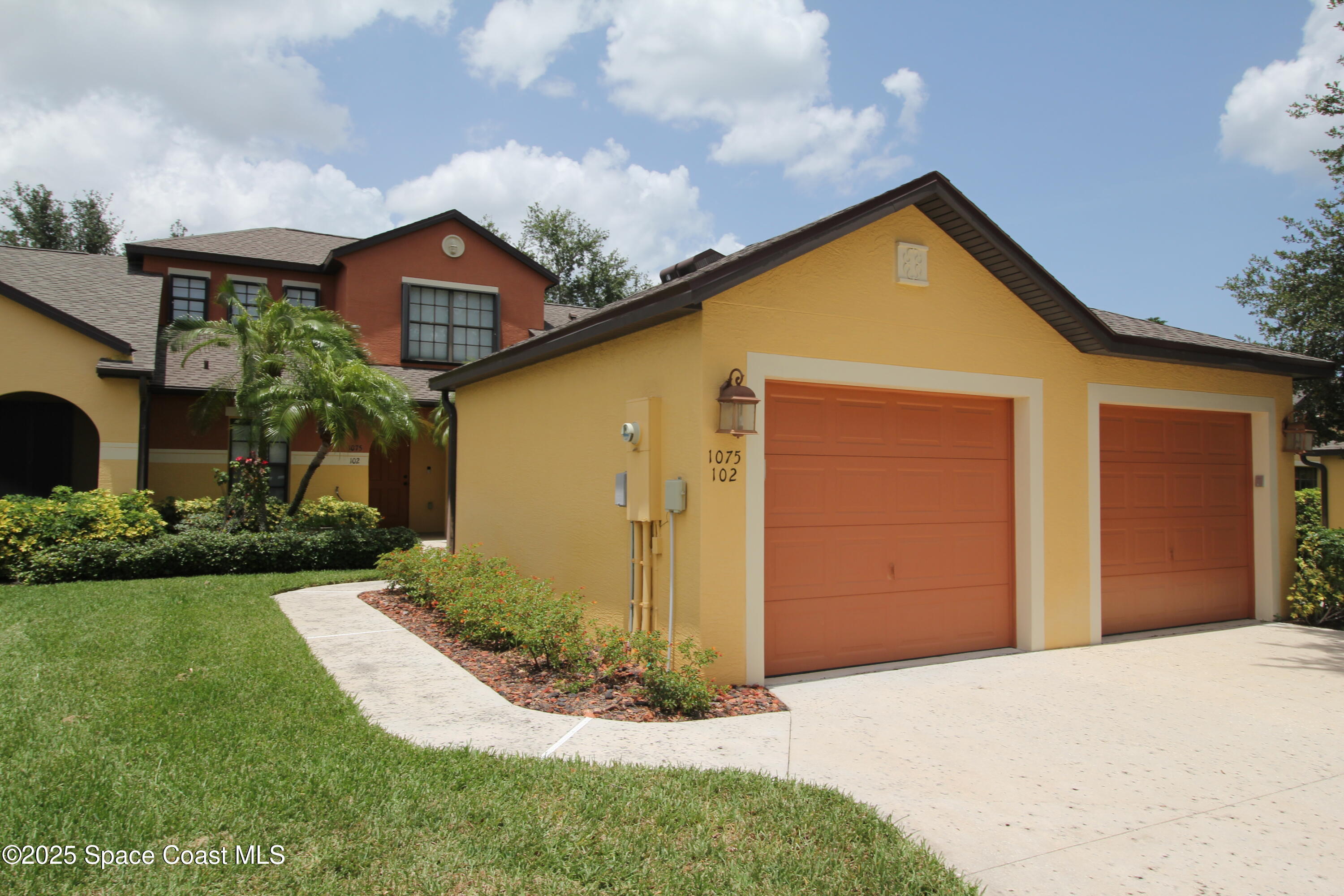 1075 Luminary Circle, Unit 102 Melbourne, FL 32901 - Photo 1 of 18 a view of a house with a yard and garage