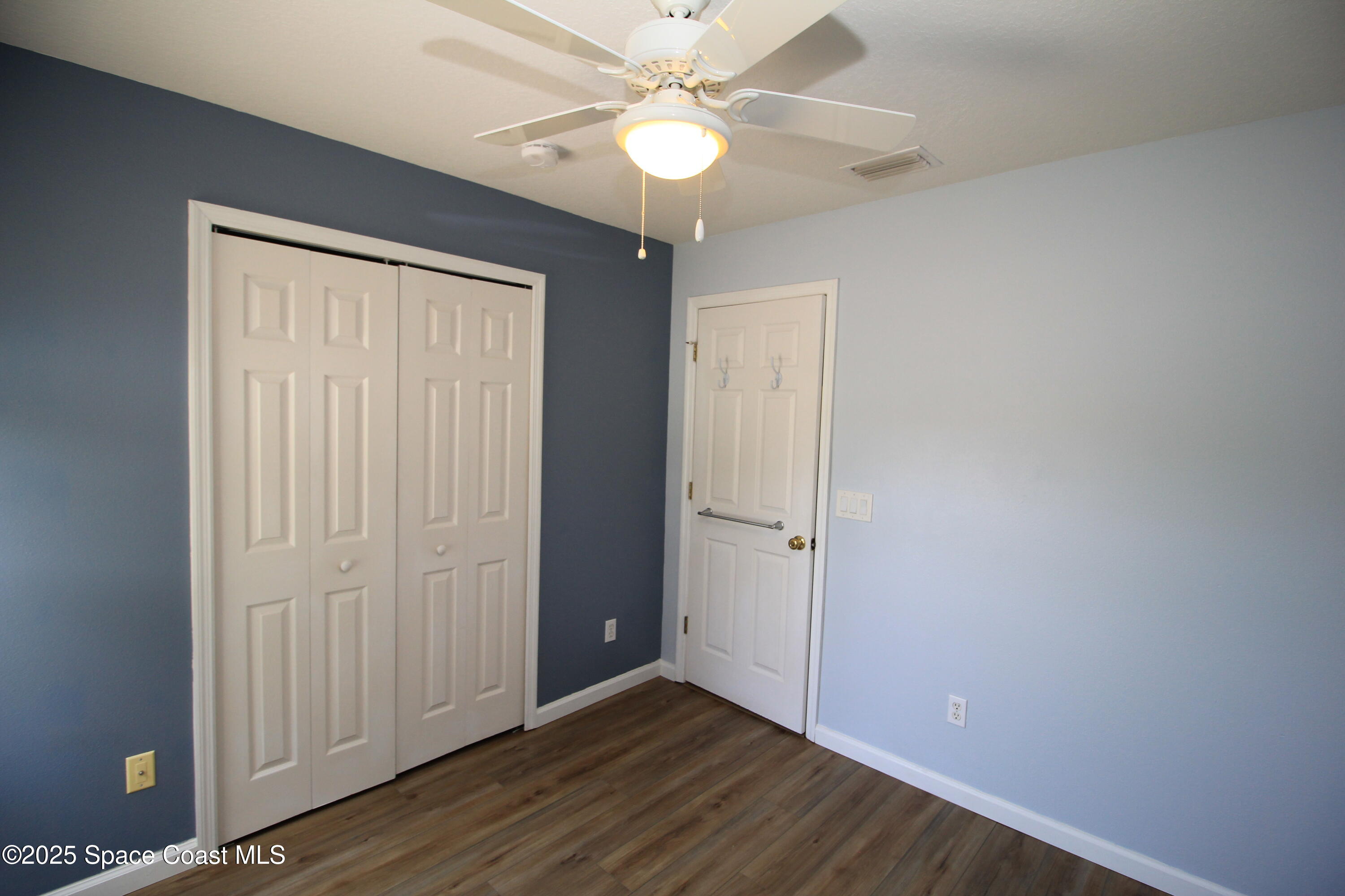 1075 Luminary Circle, Unit 102 Melbourne, FL 32901 - Photo 12 of 18 an empty room with wooden floor fan and windows
