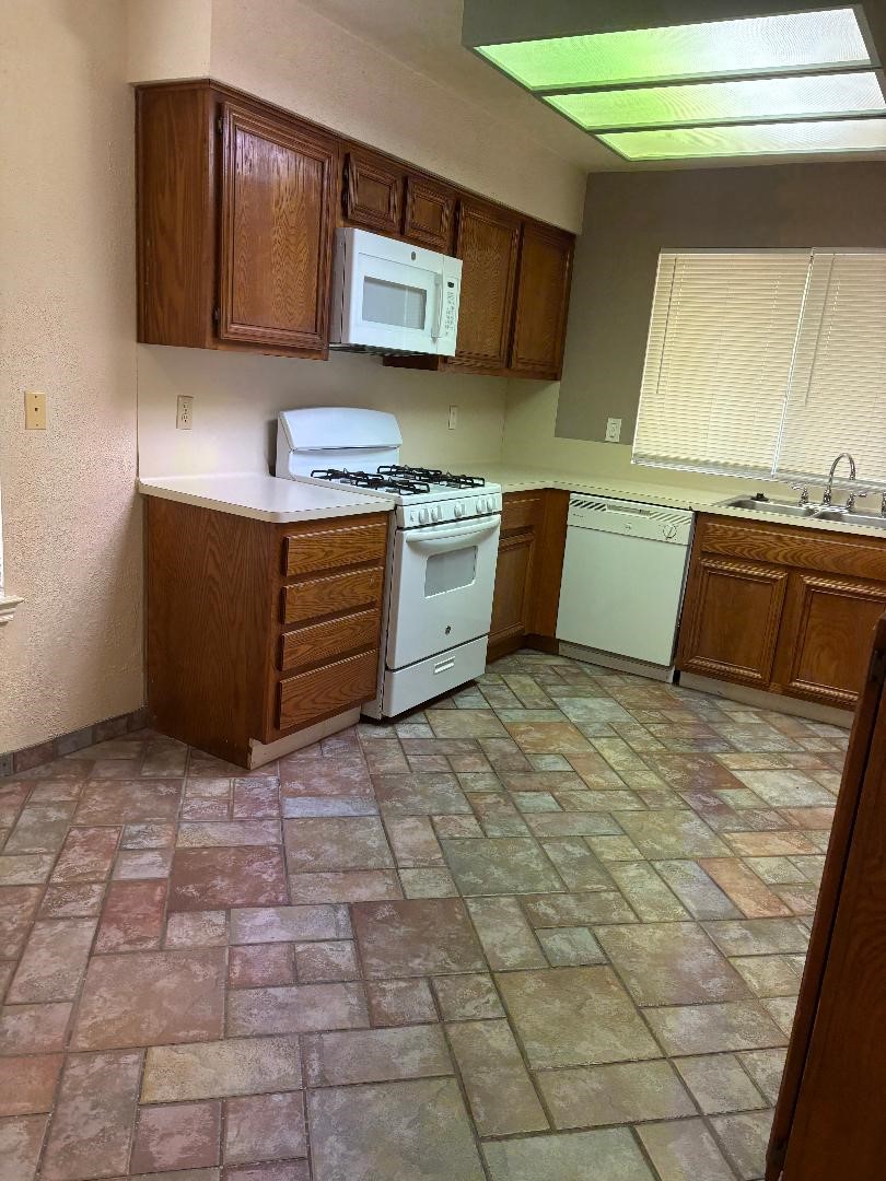 9111 Woodhouse Drive Spring, TX 77379 - Photo 2 of 7 a kitchen with a stove a sink and a microwave