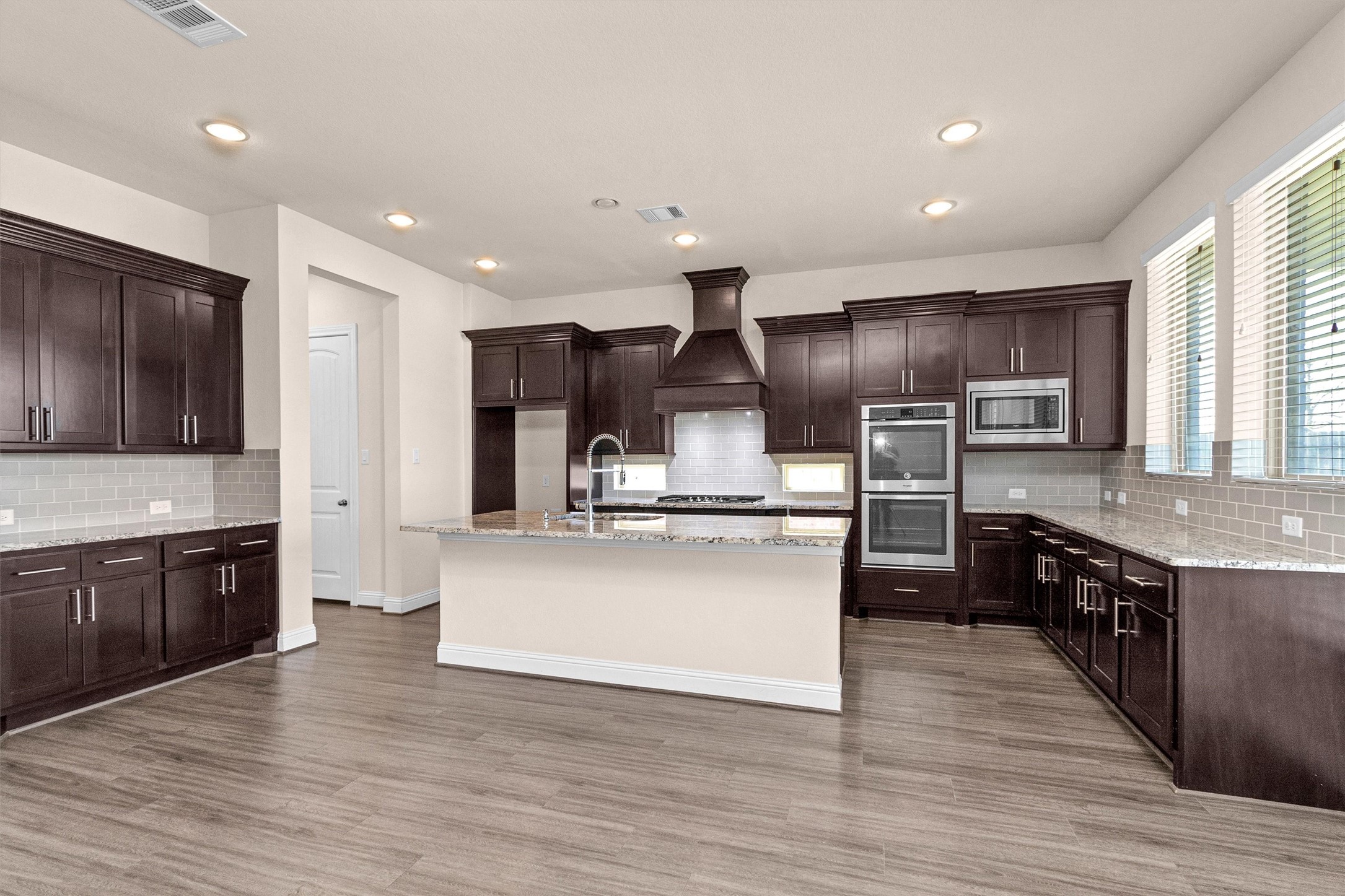 20707 Stillhaven Road Spring, TX 77379 - Photo 20 of 50 an open kitchen with wooden floor and stainless steel appliances