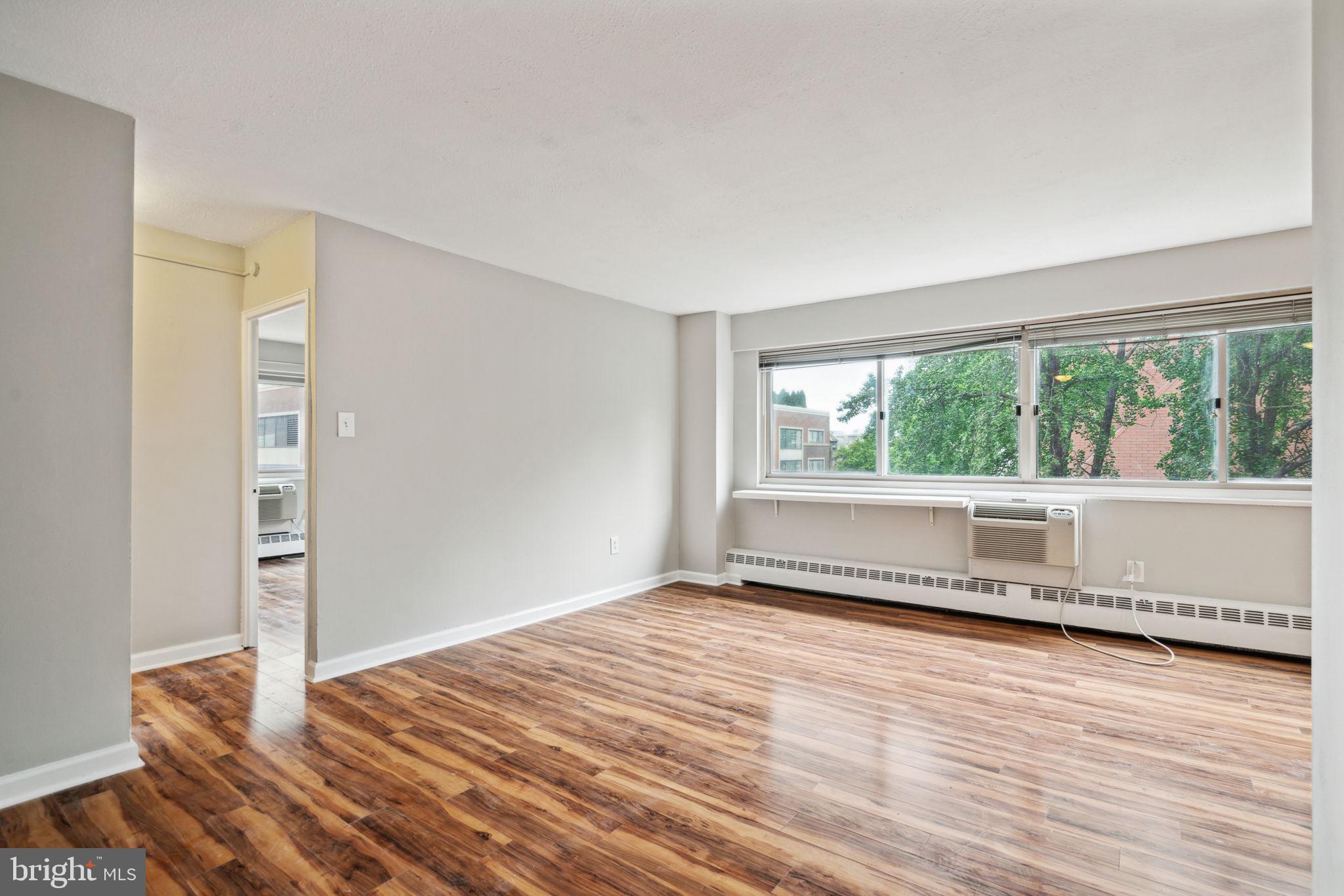 2101 Chestnut Street, Unit 415A Philadelphia, PA 19103 - Photo 3 of 20 a view of an empty room with wooden floor and a window