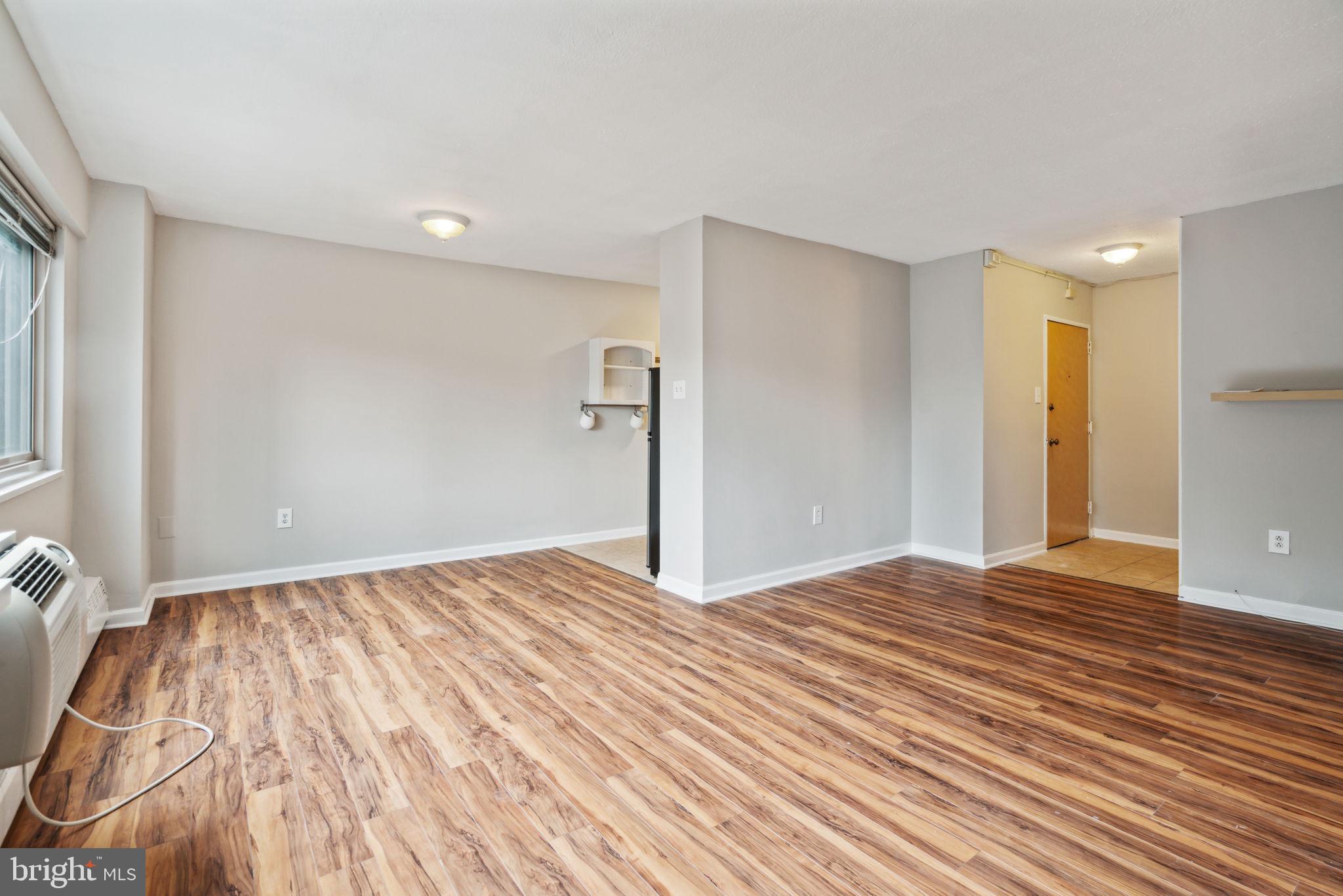 2101 Chestnut Street, Unit 415A Philadelphia, PA 19103 - Photo 4 of 20 a view of an empty room with wooden floor and a window