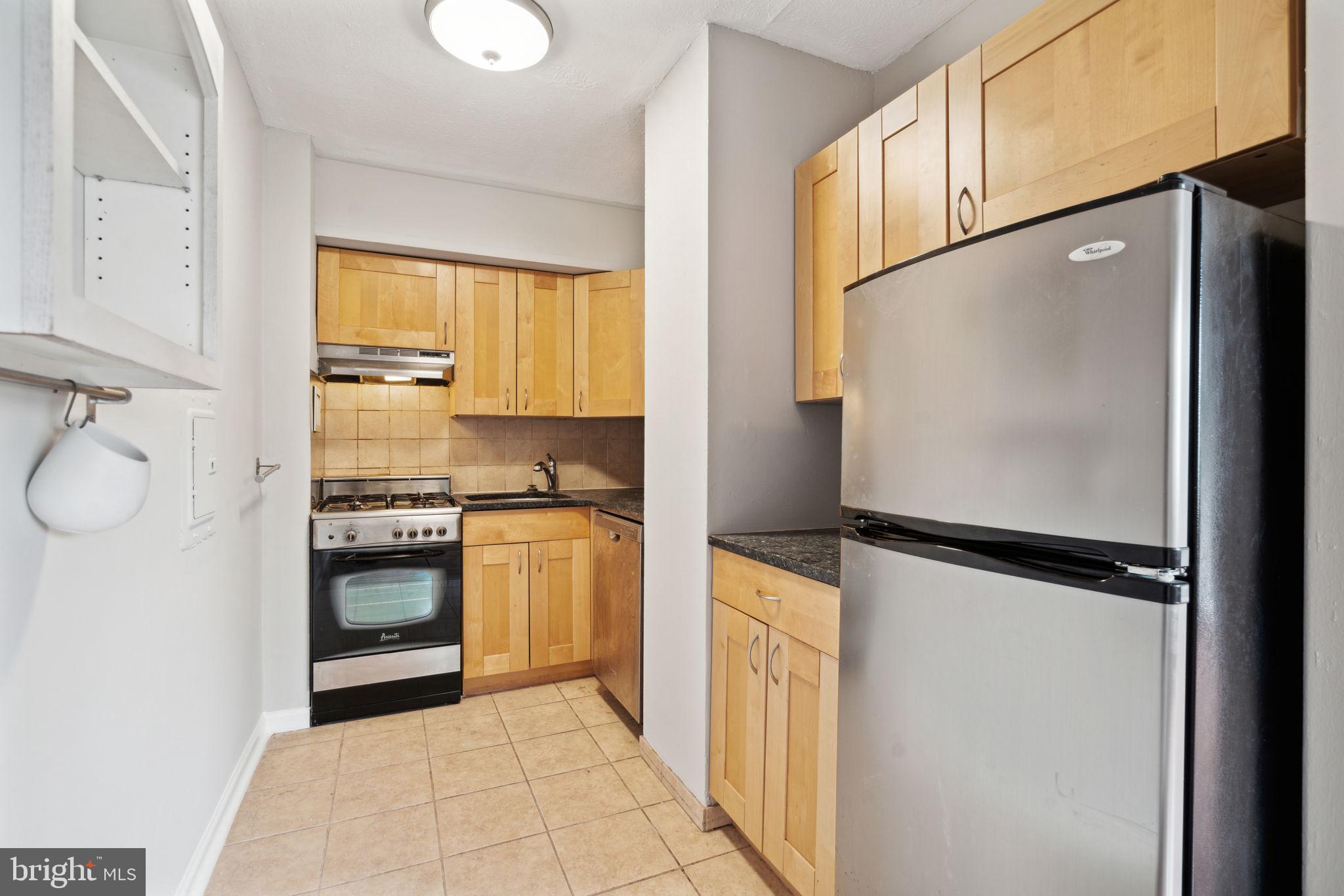 2101 Chestnut Street, Unit 415A Philadelphia, PA 19103 - Photo 5 of 20 a kitchen with a refrigerator and a stove top oven