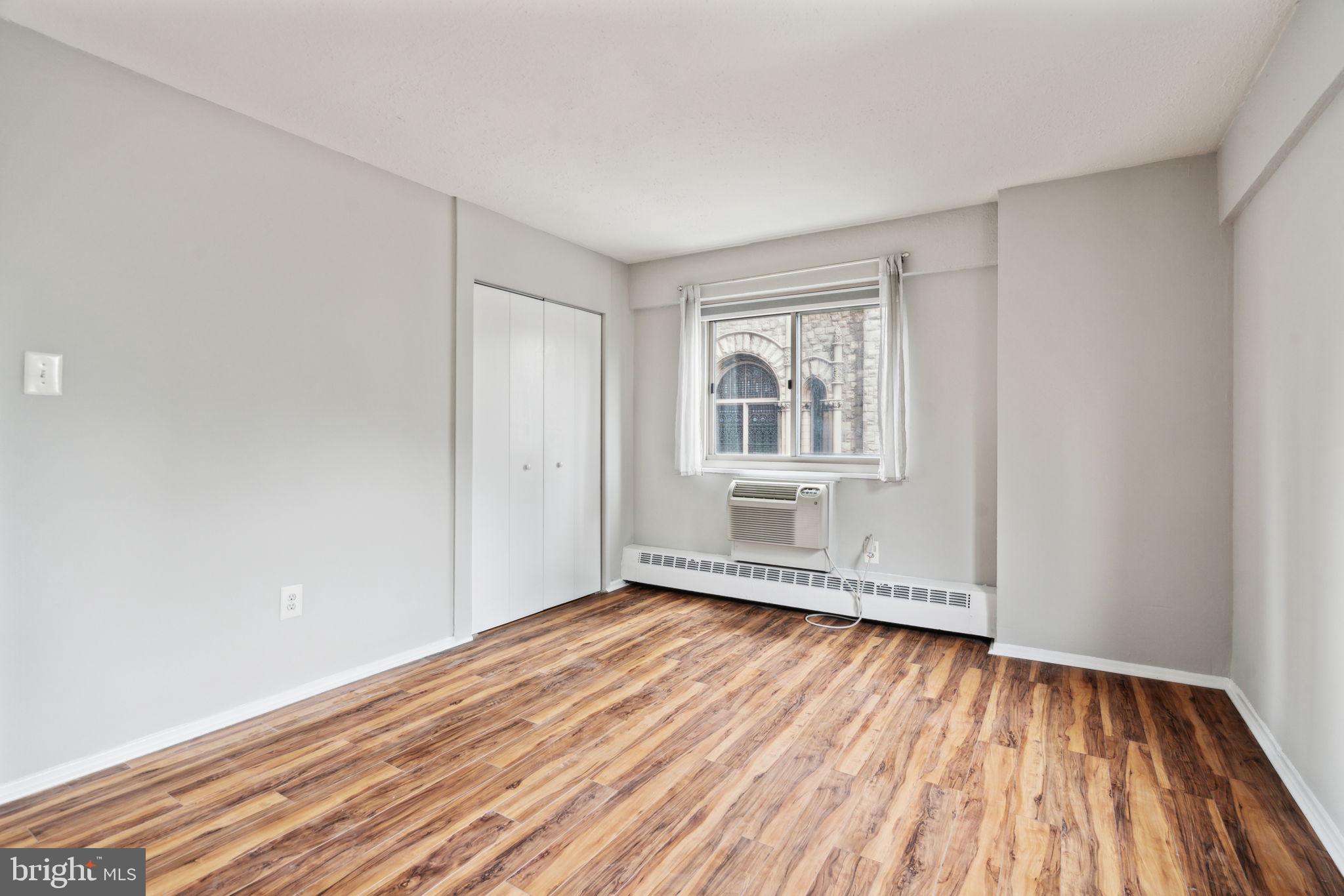 2101 Chestnut Street, Unit 415A Philadelphia, PA 19103 - Photo 7 of 20 an empty room with wooden floor and windows
