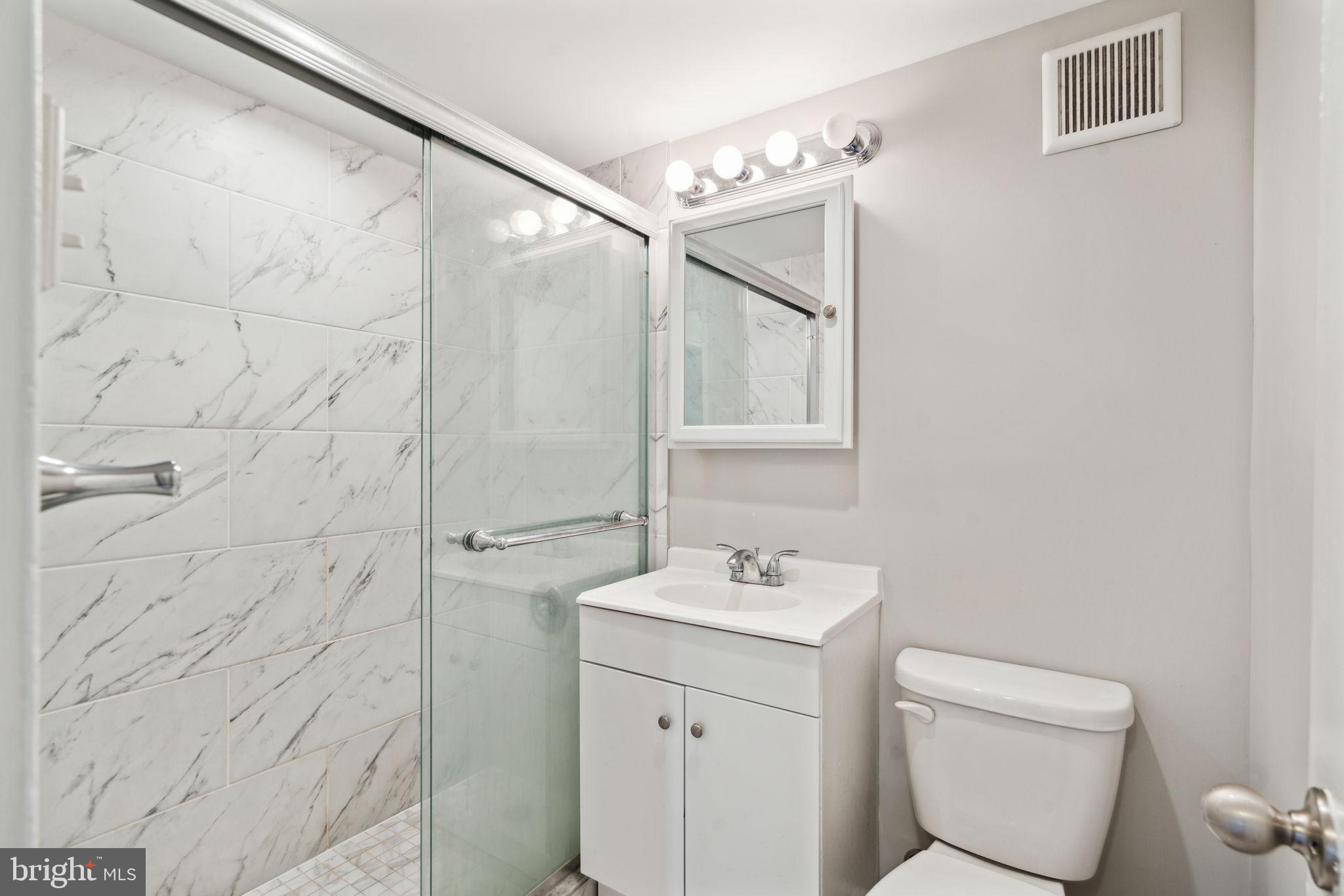 2101 Chestnut Street, Unit 415A Philadelphia, PA 19103 - Photo 9 of 20 a bathroom with a toilet sink and mirror