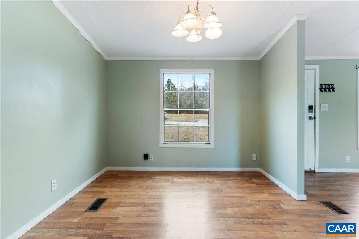 9319 3 Notch Road Louisa, VA 23093 - Photo 4 of 22 a view of an empty room with wooden floor and a window