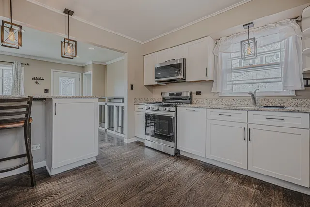 a kitchen with stainless steel appliances granite countertop a stove a sink and a refrigerator