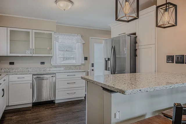 a kitchen with granite countertop white cabinets stainless steel appliances and sink