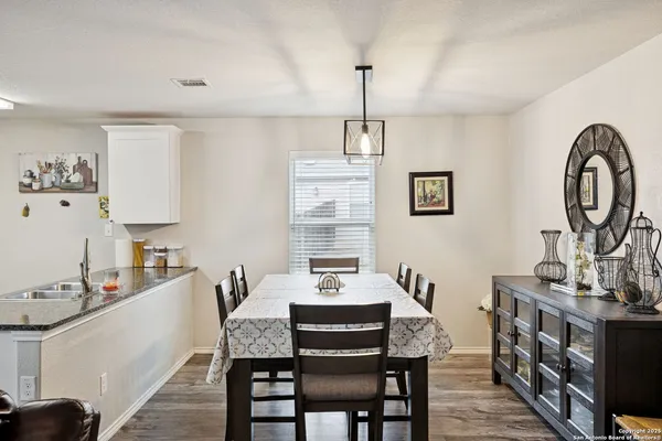 a view of a dining room with furniture a kitchen and chandelier