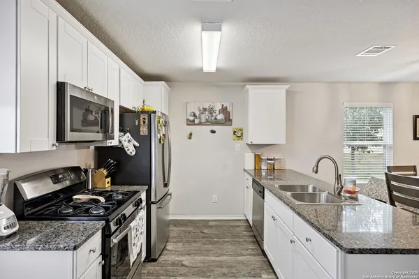a kitchen with granite countertop a refrigerator and a sink