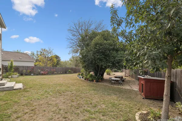 a view of a yard with wooden fence