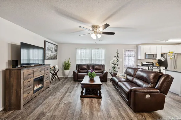 a living room with furniture kitchen view and a fireplace