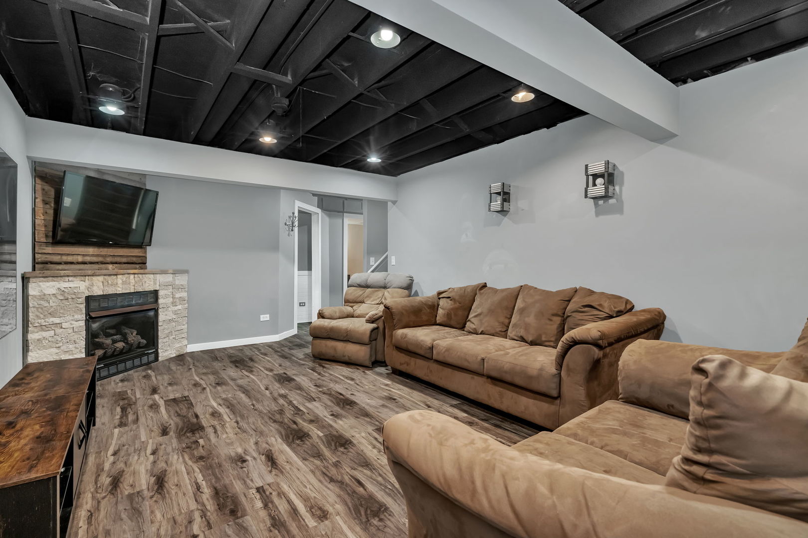 1605 Heritage Pointe Court Plainfield, IL 60586 - Photo 16 of 21 a living room with furniture a flat screen tv and a fireplace