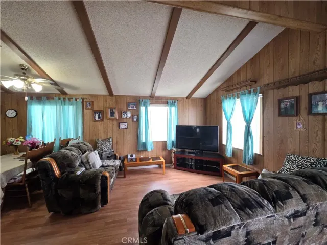 a bedroom with furniture a flat screen tv and a large window