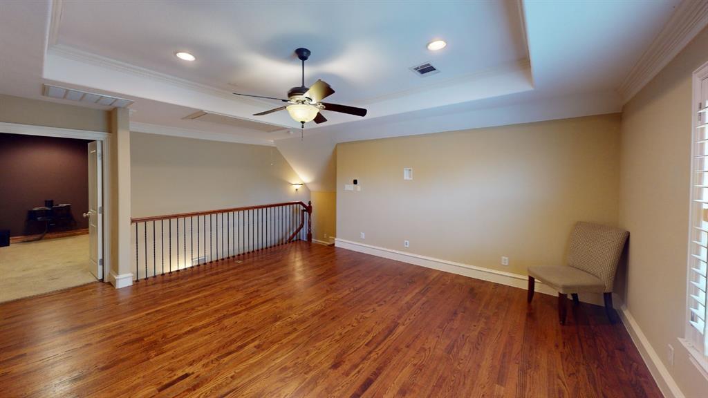 4516 Gilbert Avenue Dallas, TX 75219 - Photo 10 of 28 Spacious room featuring rich wood-finish flooring, a tray ceiling with a ceiling fan, recessed lighting, and white plantation shutters