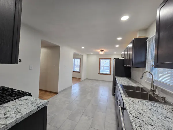 a kitchen with stainless steel appliances granite countertop a sink and a stove