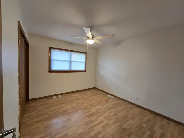 an empty room with a ceiling fan and a window