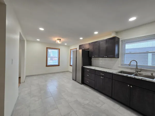 a large kitchen with stainless steel appliances granite countertop a sink and a stove